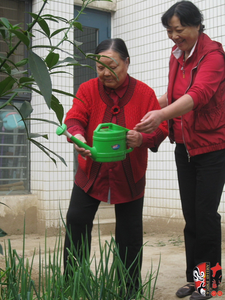 馬金鳳和女兒在小花園澆花