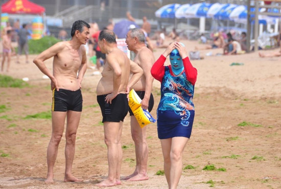 2013年7月3日，山東青島青島高溫來襲，“青島大媽”不懼滸苔，戴著“強盜面具”出現(xiàn)在海水浴場消暑降