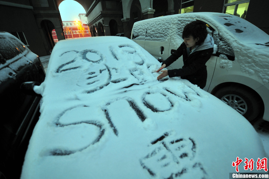 11月18日，行人在車輛的積雪上涂鴉。