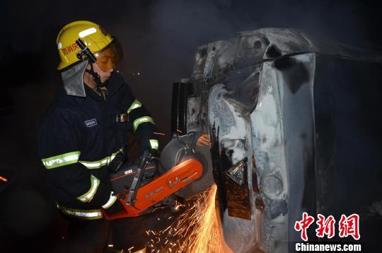 圖為消防人員破拆轎車(chē)，尋找4萬(wàn)元現(xiàn)金。嚴(yán)光濤 攝