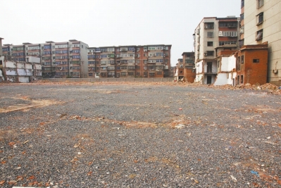 為降塵，旮旯王村拆遷后裸露的地面上鋪了一層石子。