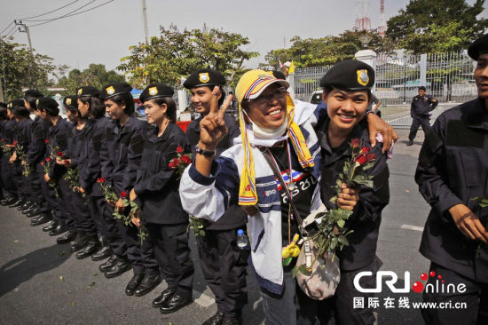 2013年12月03日,曼谷總理府與曼谷警署允許反政府示威民眾進(jìn)入,雙方進(jìn)入暫時(shí)“停戰(zhàn)”狀態(tài)迎接泰王生日。曼谷警察總署,女警們手持鮮花送給反政府示威民眾。圖片來源:Manish Swarup/東方IC