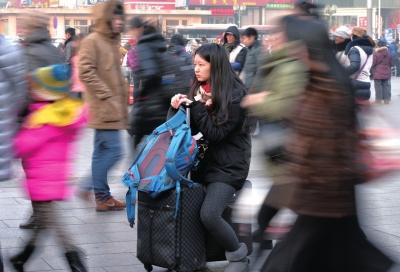 春運(yùn)首日，北京站客流量明顯增多，一名女孩在人流中等待進(jìn)站。