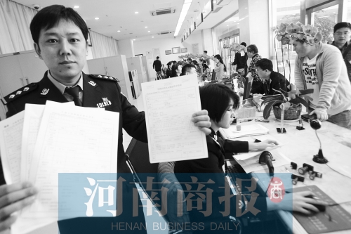 　民警左手拿的是新申請表，右手拿的是三份老申請表 王春勝/攝