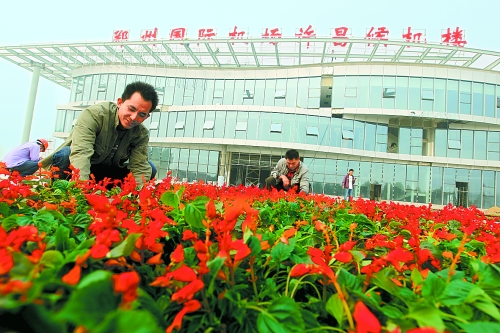 9月23日，工人們正在鄭州國際機場許昌候機樓前擺放鮮花。