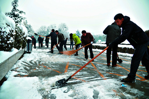 干部職工走上街頭清掃積雪保暢通