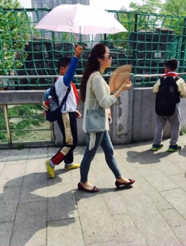 小學生為女教師打陽傘