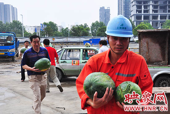 愛心的哥的姐將買來的西瓜送給工地上的工人