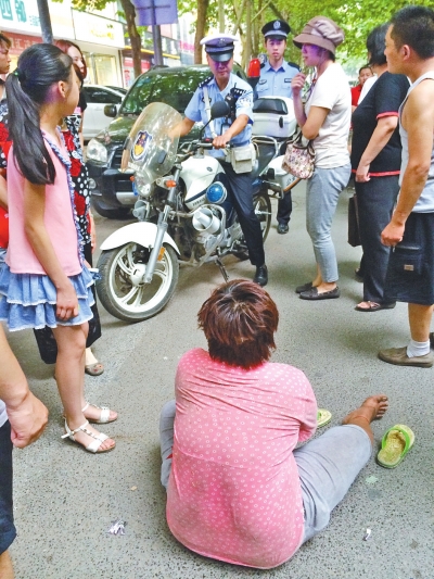 在鄭州優(yōu)勝南路東三街交叉口向東100米處，一名短發(fā)中年女子平躺在路南快車道上，身旁還有一只掉落的拖鞋