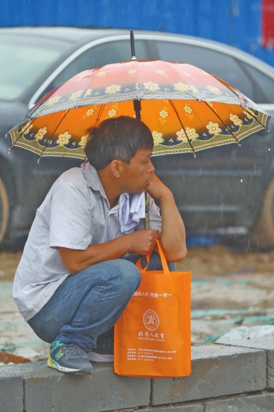 冒雨守在考點(diǎn)門外牽腸掛肚的家長(zhǎng)