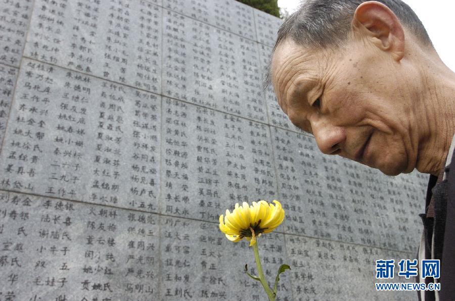 2006年4月5日，74歲的南京大屠殺幸存者佘子清手捧鮮花，祭奠被日軍殺害的母親。