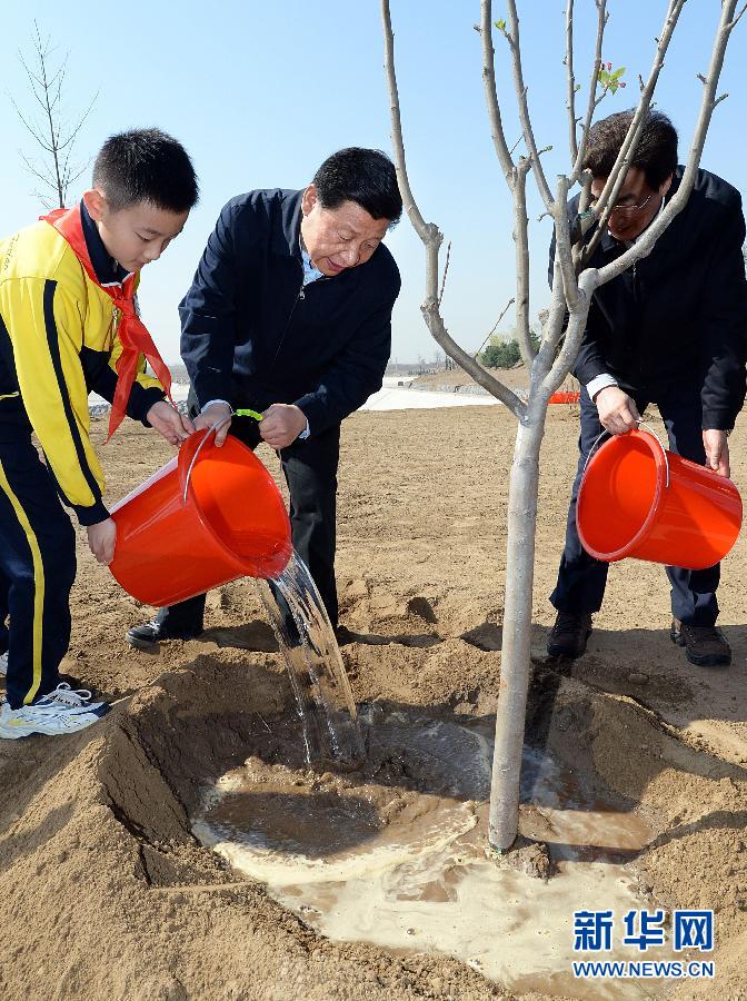 這是習近平同大家一起給剛栽下的樹苗澆水。