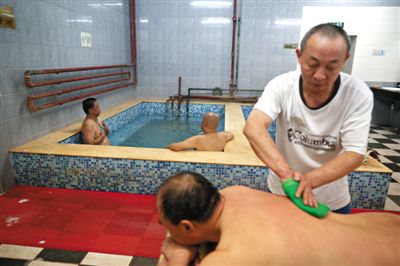 客人在搓澡。近日，百年歷史的鑫園浴池宣布將關(guān)張。新京報記者