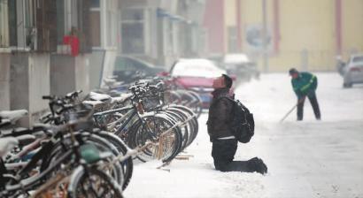 小伙子跪在樓前，一直抬頭看著樓上。 孫立國/攝