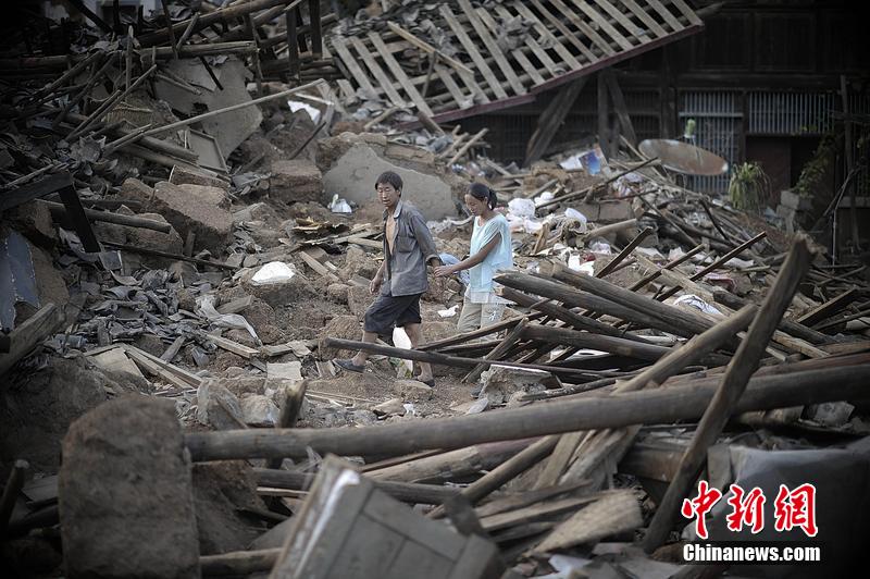 2014年8月5日，云南昭通龍頭山鎮(zhèn)老街，一對夫妻從居住房屋的廢墟中走過。