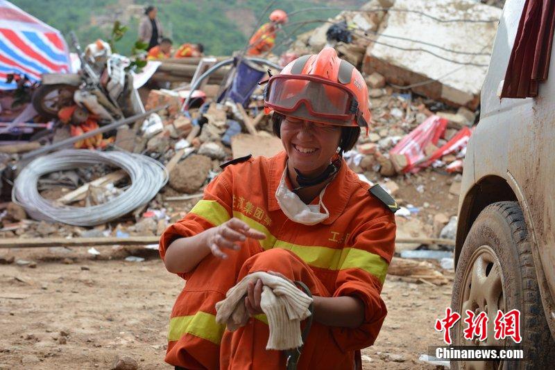 2014年8月5日，女兵在云南魯?shù)辇堫^山鎮(zhèn)廢墟中搜救被困者。