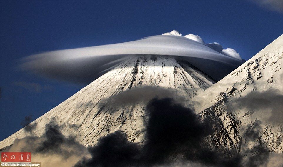 火山上籠罩著類似于外星飛碟形狀的云彩，場景猶如科幻大片。