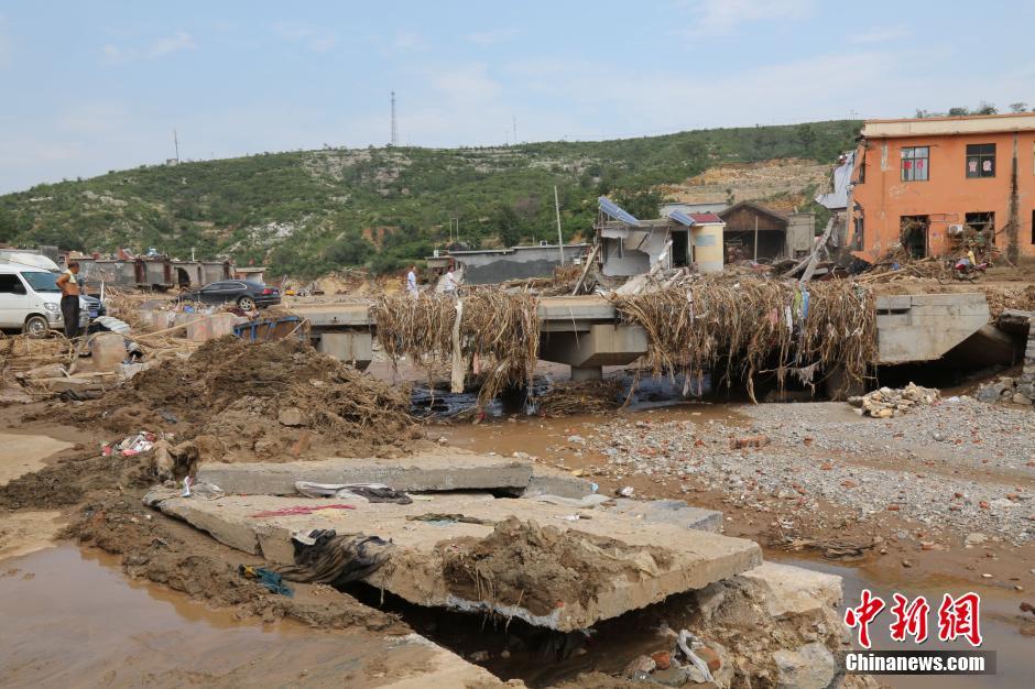 圖為洪水過后，坍塌的橋梁上遺落大量雜草。